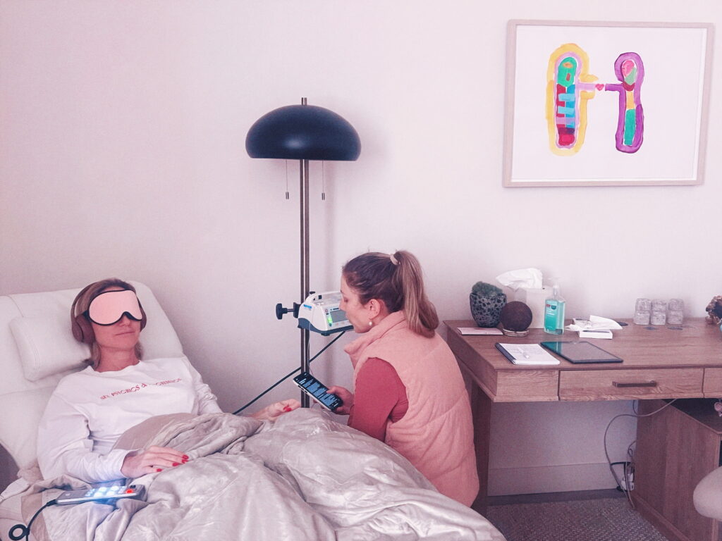 IV therapy for energy provided in a calming home setting with a patient resting under a blanket and eye mask.