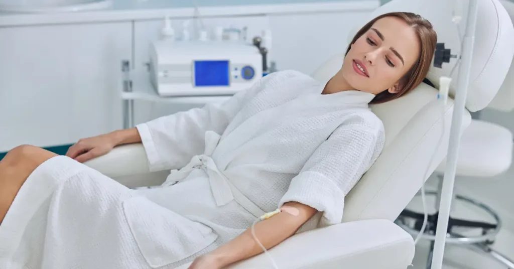 Vitamin infusion clinic patient receiving an IV drip while resting comfortably in a treatment chair.
