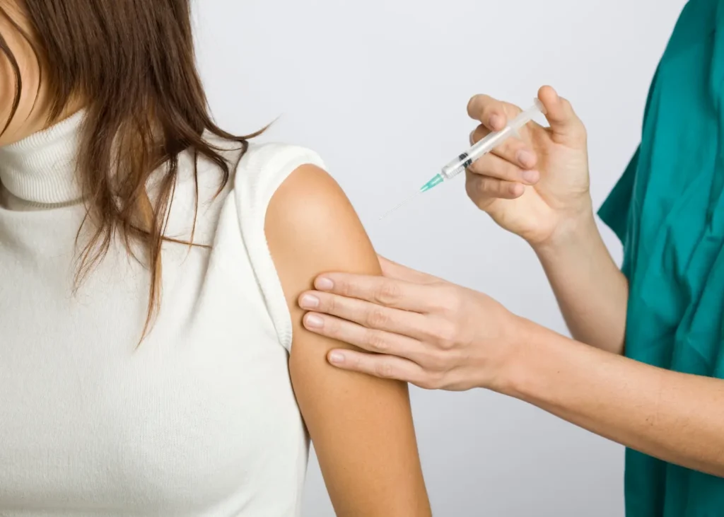 IV vitamin injections being administered into a woman’s upper arm by a healthcare professional