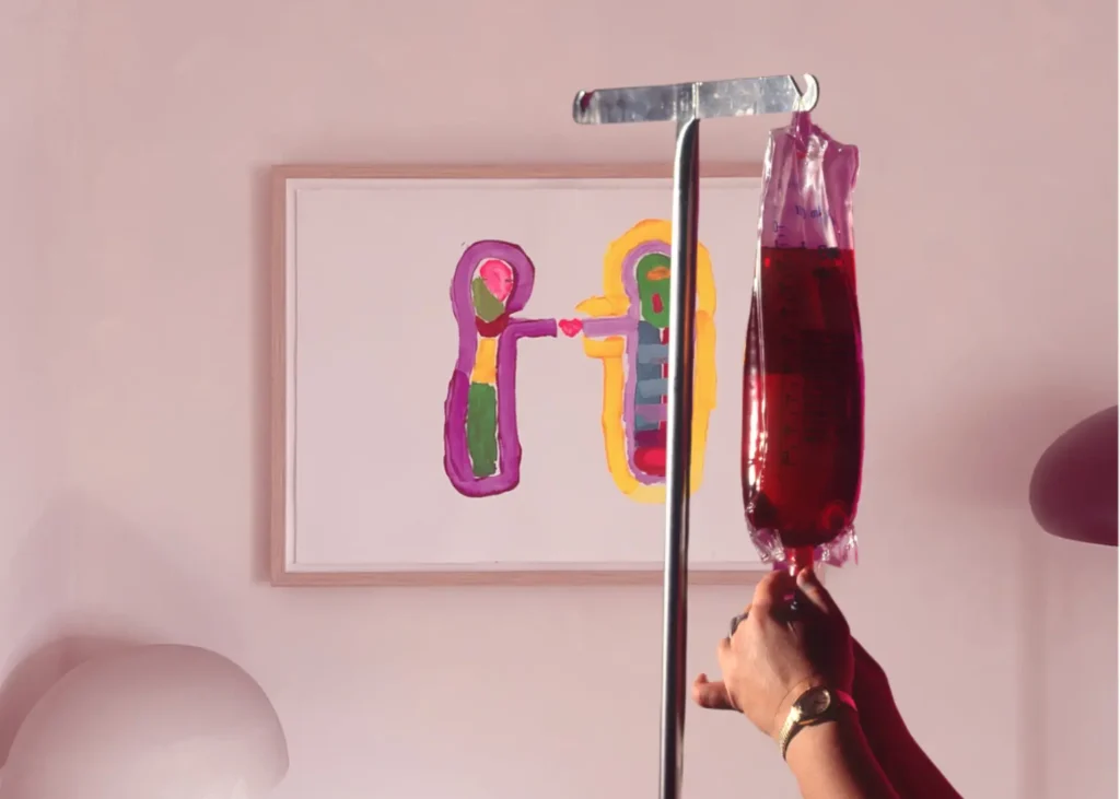 Depression infusion treatment featuring a red IV bag beside abstract artwork in a calming therapy room.