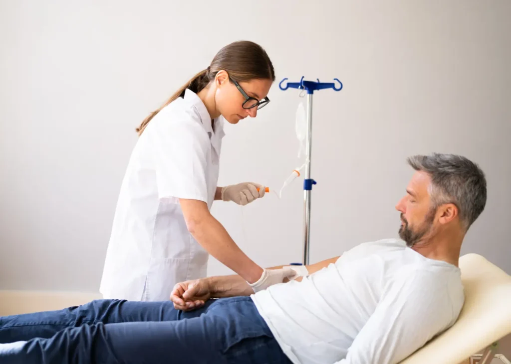 Ketamine for anxiety and depression administered through an IV drip by a healthcare professional to a seated man.